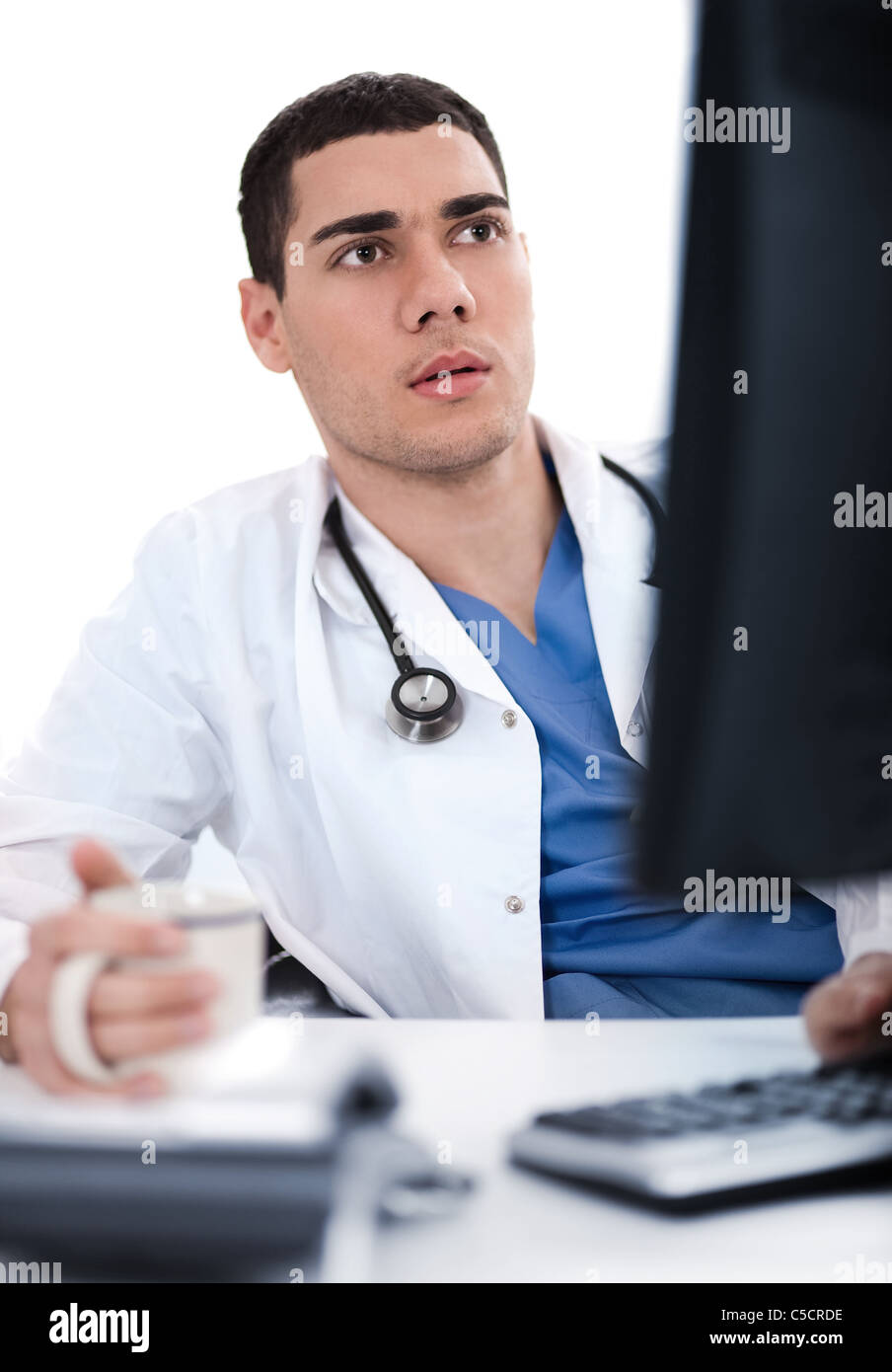 Junge ethnischen Arzt tief mit Blick auf den Computer in seinem Büro Stockfoto