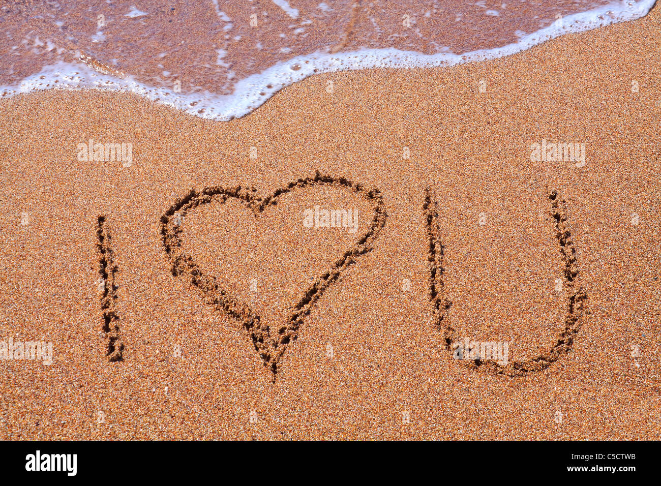 Schreiben auf dem Sand mit Wasser kommt es zu löschen Stockfoto