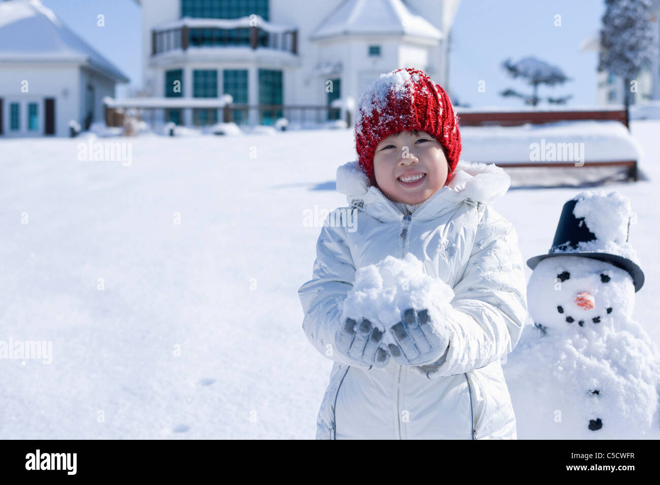 Mädchen Schnee auf ihrer Hand mit Schneemann Stockfoto