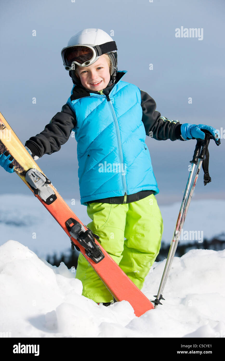 In voller Länge Portrait eines kleinen Jungen in Skibekleidung Stockfoto