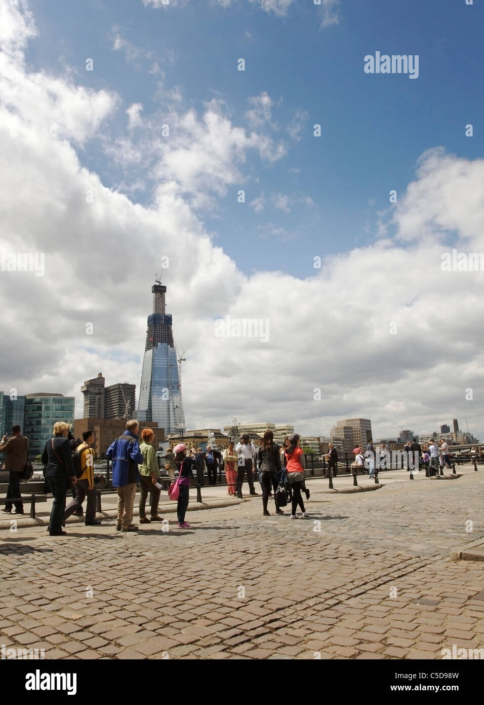 Touristen Sightseeing am Nordufer der Themse und die Scherbe unter Bau im Hintergrund. Stockfoto