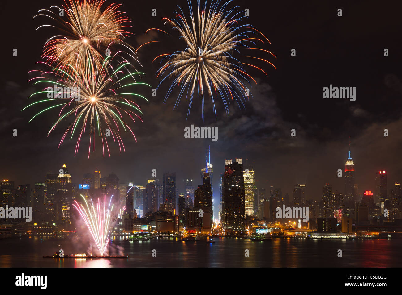 Die Macy's 4. Juli leuchtet den Himmel über die Skyline von Midtown Manhattan Feuerwerk und Hudson River in New York City. Stockfoto