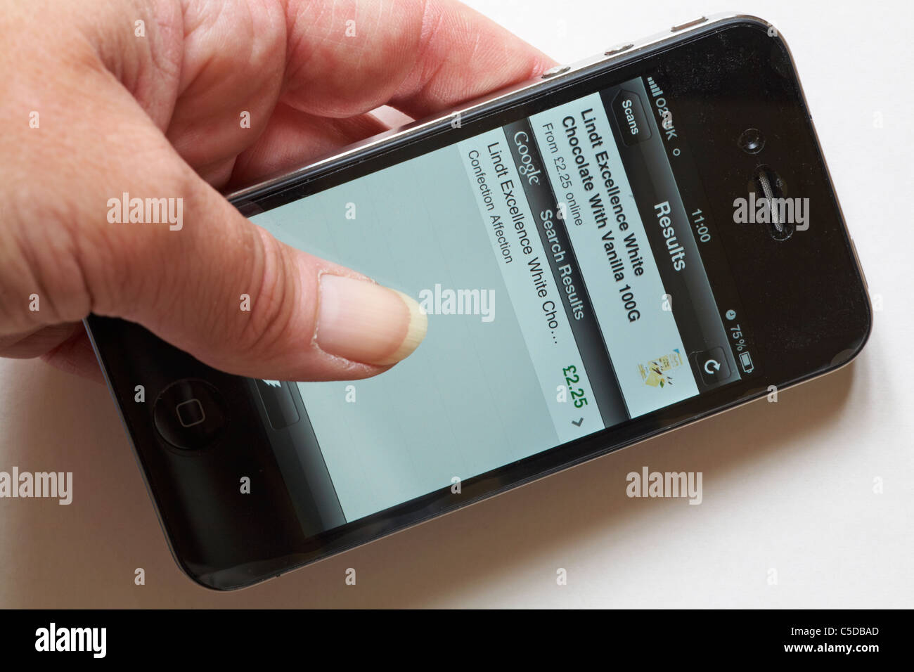 Hand halten Iphone 4 Resultate Scans app zu verwenden, um herauszufinden, Preis von Lindt Schokolade aus Barcode auf weißem Hintergrund Stockfoto
