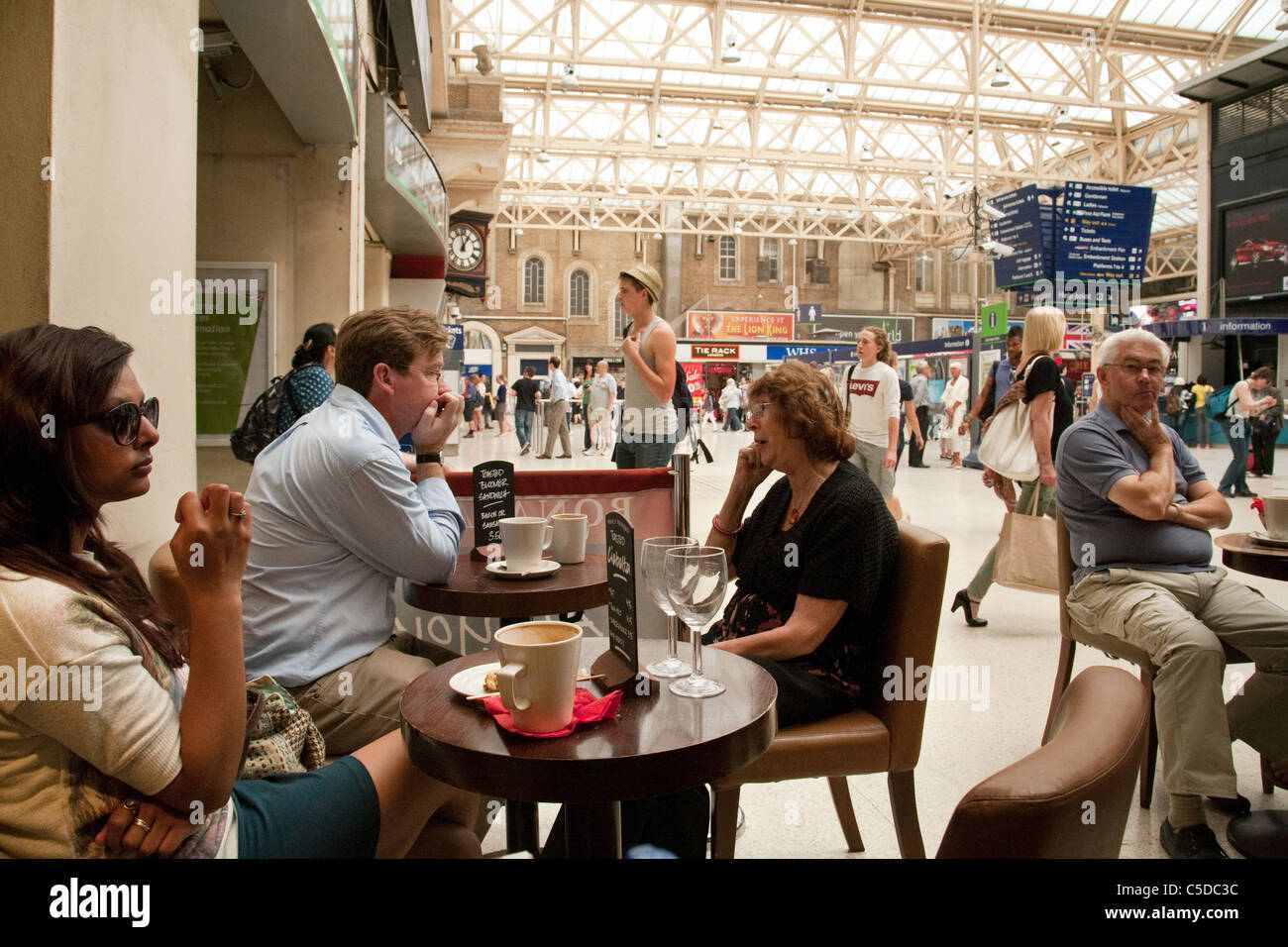 Leute sitzen in einem Café, Bahnhofshalle Charing Cross, London UK Stockfoto