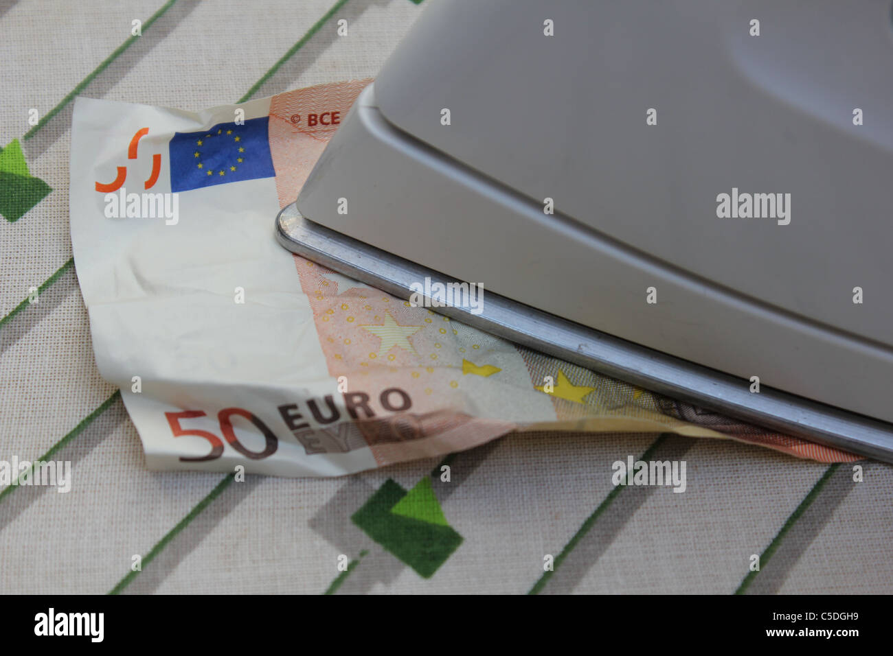 Glättung einer zerknitterten 50-Euro-Schein mit einem flatiron Stockfoto