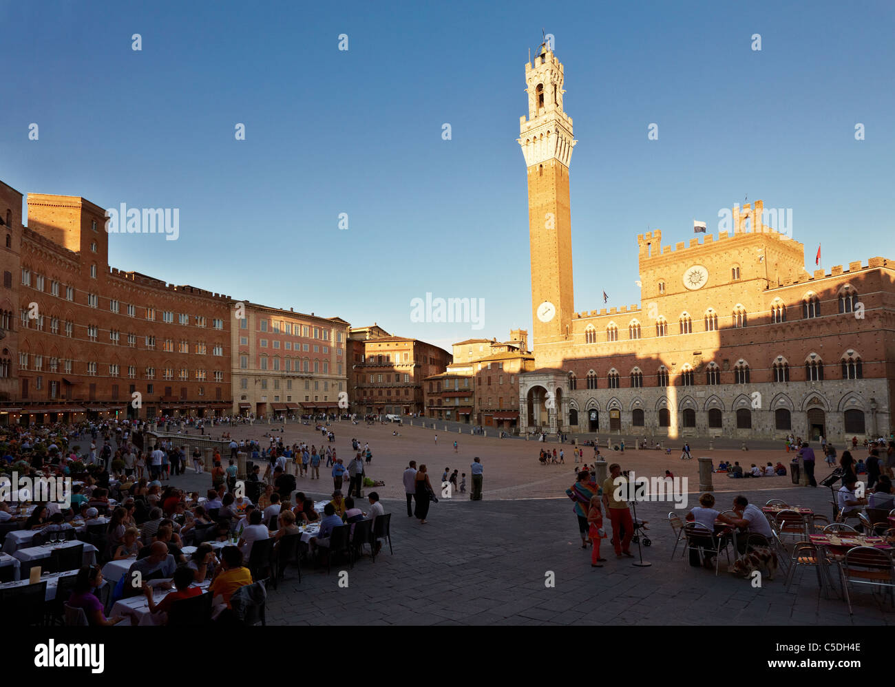Gäste und Touristen beobachten den Sonnenuntergang über der Piazza del Campo in Siena, Toskana, Italien Stockfoto