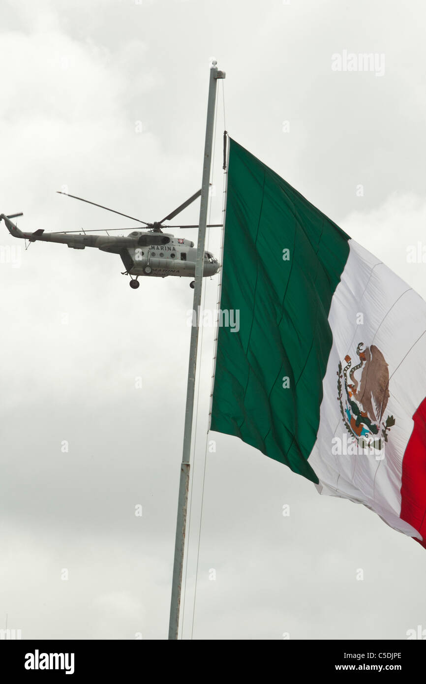 Eine mexikanische Marine Militärhubschrauber Patrouillen Flusses Rio Grande, wie es bei der US-Grenze mit einer großen mexikanischen Flagge vorbeifliegt Stockfoto