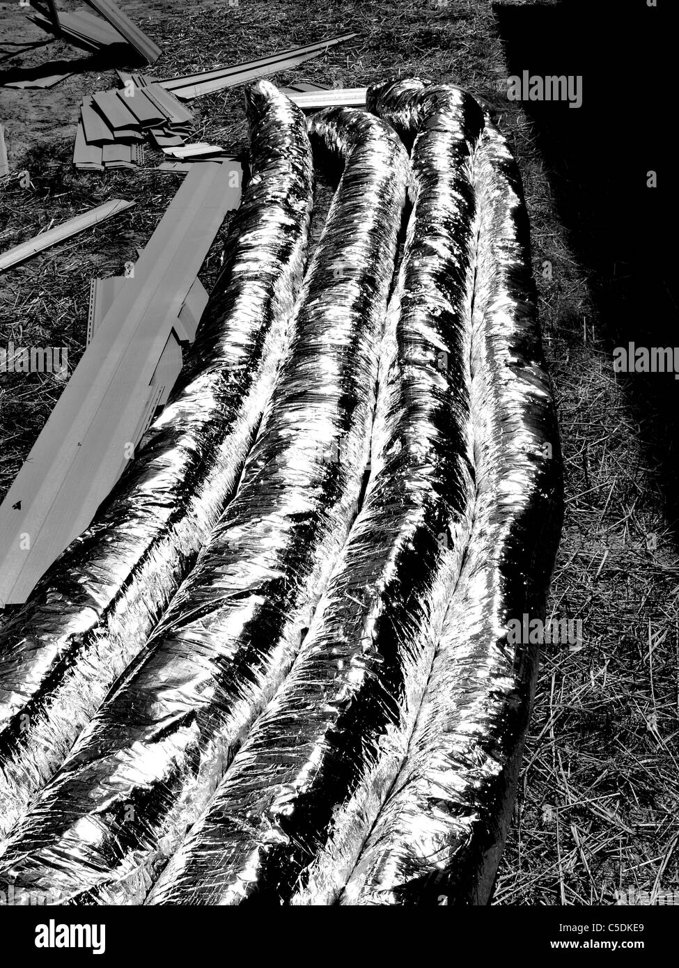 Bau Materialschläuche Rohrleitungen Heizung Klimaanlage isoliert Luftkanäle Silber glänzend auf Boden Stockfoto