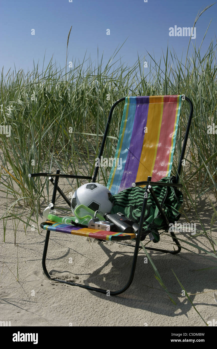 Ansicht von Ball und Handtuch im Liegestuhl auf Sand gegen hohe Gräser und  klaren, blauen Himmel Stockfotografie - Alamy