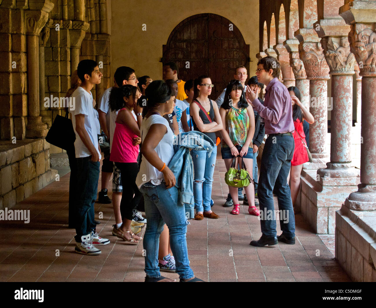 Ein Dozent findet eine High-School-Reisegruppe durch die mittelalterlichen französischen Cuxa Kreuzgang in The Cloisters Museum in New York City. Stockfoto