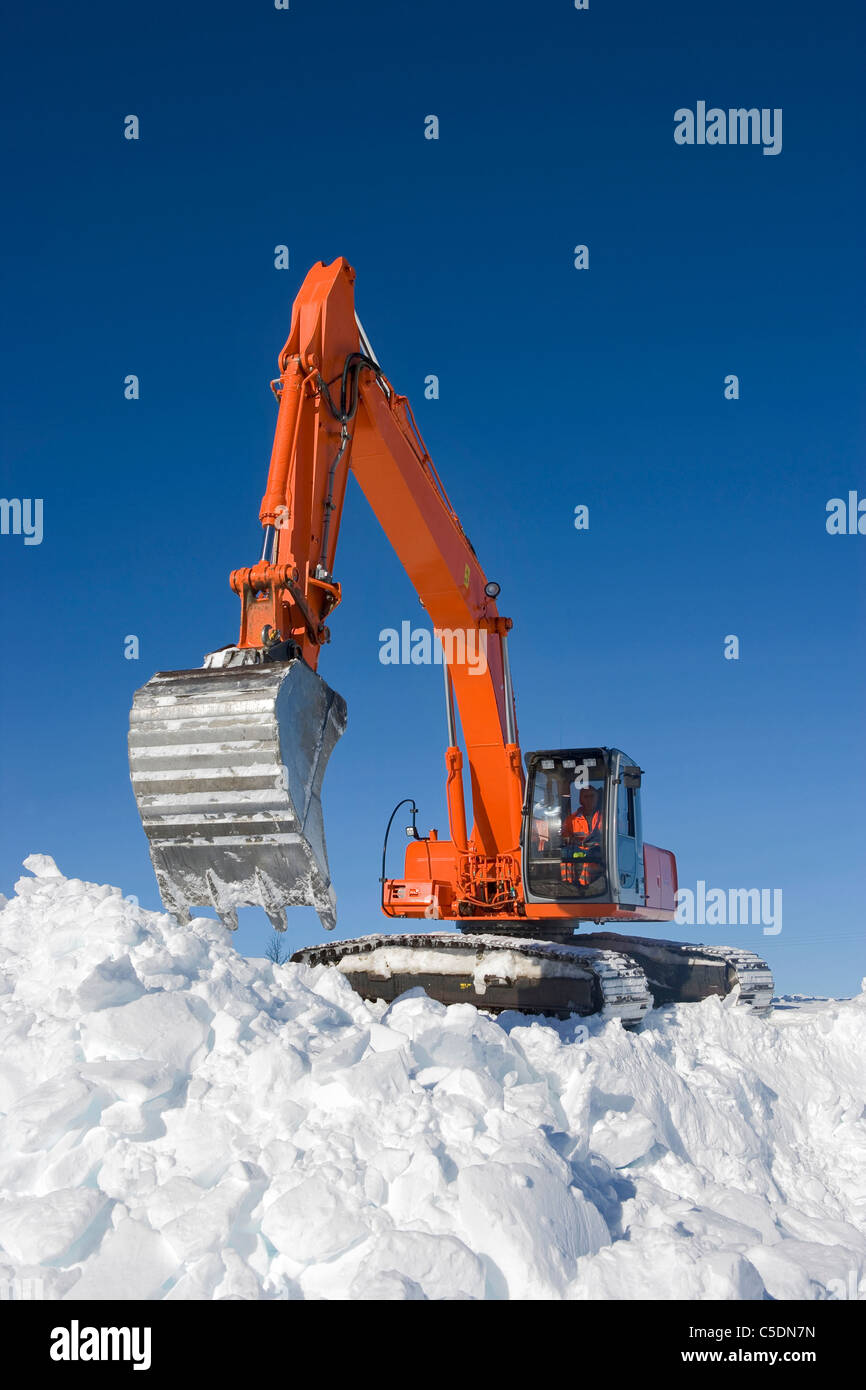 Niedrigen Winkel Ansicht eines Baggers bei der Arbeit im Schnee gegen blauen Himmel Stockfoto