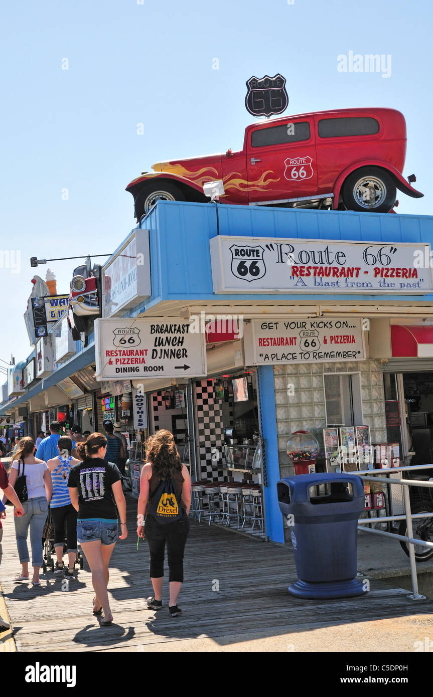 Besucher schlendern durch ein Restaurant an der Strandpromenade von Wildwood NJ, die Route 66 feiert. Ein Automobil auf dem Dach ist ein Teil davon Stockfoto