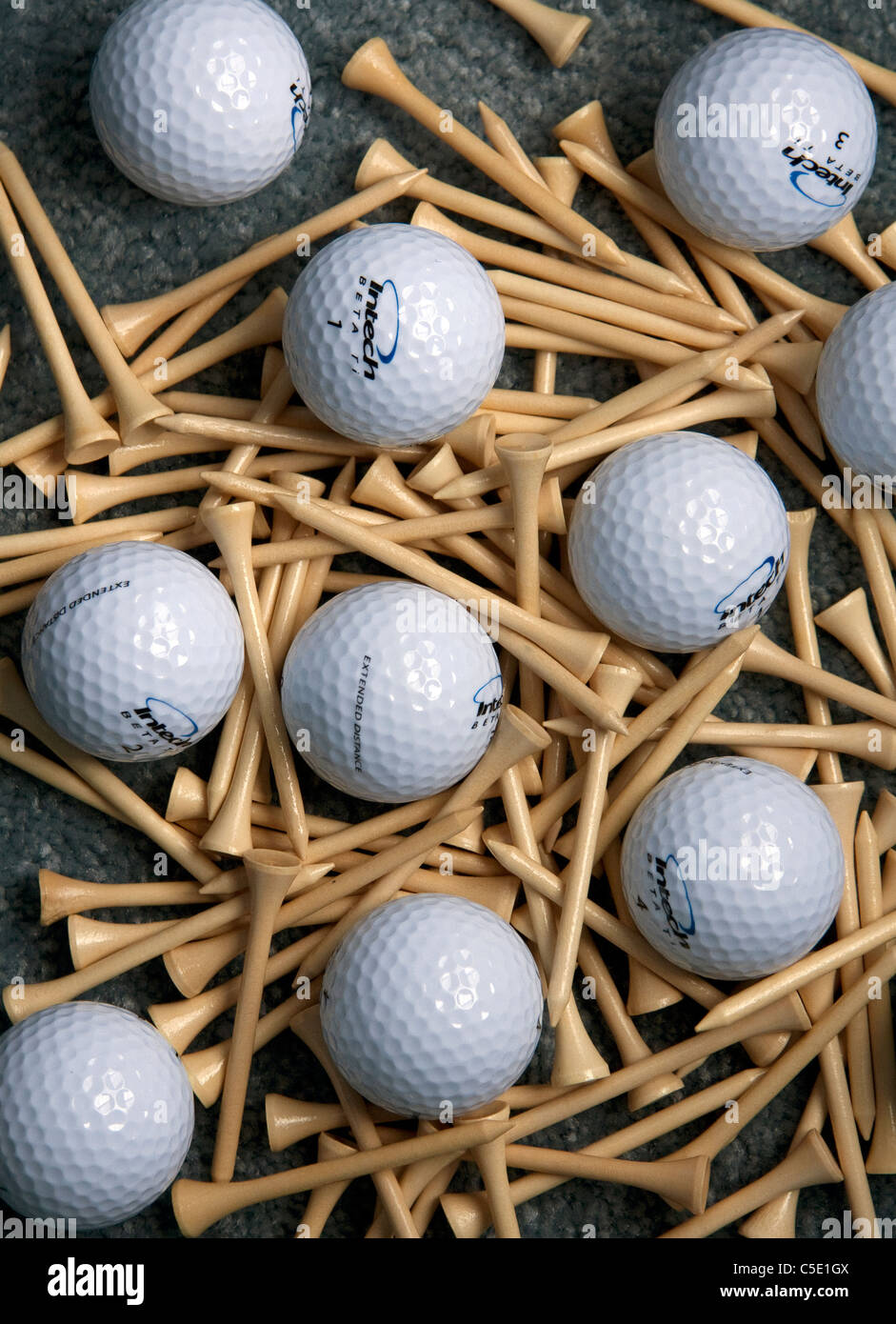 Ein Golf-Themen abstrakte Stilleben, bestehend aus 10 glänzende neue Golf, die Kugeln, symmetrisch gruppiert in Reihen mit Tees vermischt. Stockfoto