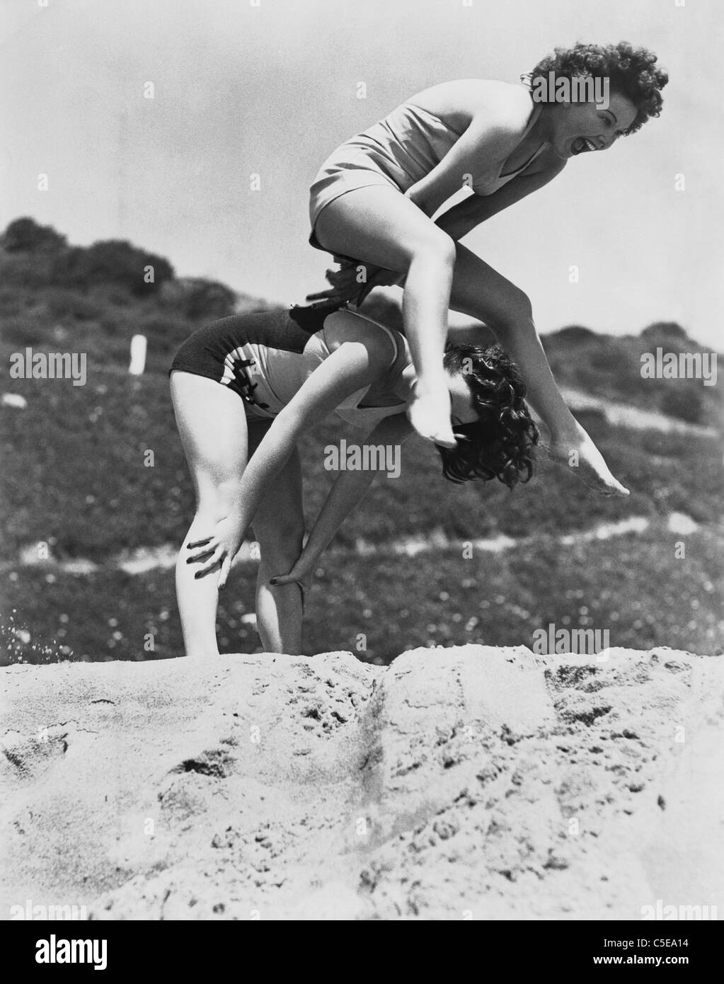 Junge Frauen spielen Leap frog Stockfoto