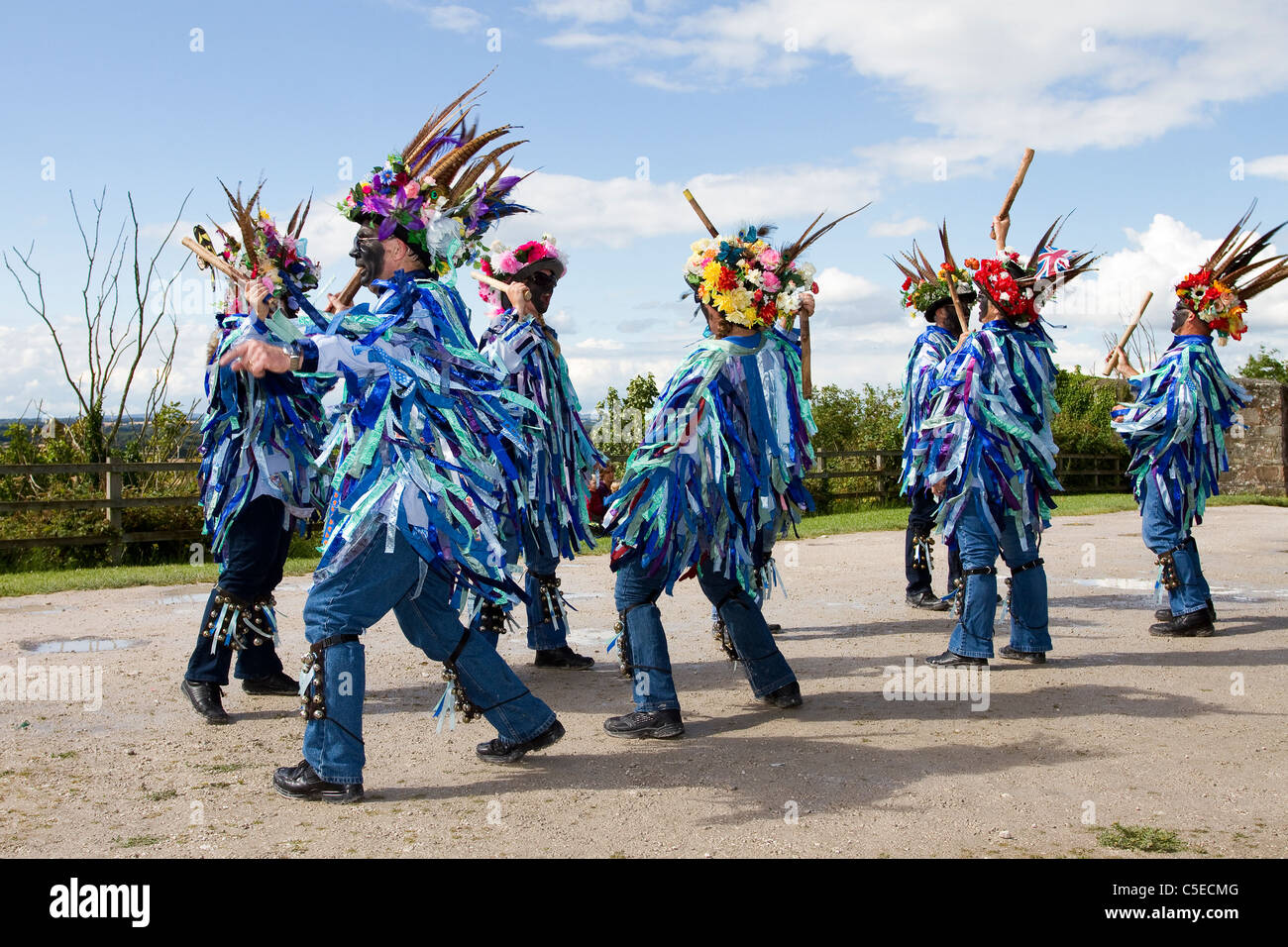 Exmoor Border Morris Tänzer, schwarz gesichtig, tragen lange fließende zerrissene alte Lumpen, Kleidung aus breiten Bolzen aus blauem und weißem Material, Kleidung & Tanzfeier, Outdoor-Veranstaltung, Street Dancer, kostümierte Tänzer, lange fließende Lumpen, Cloggies, führen, Leistung der Volksunterhalter, bunte Musiker, beliebt, Traditionelle Unterhaltung im Tutbury Castle Weekend of Dance Derbyshire, Großbritannien. Stockfoto