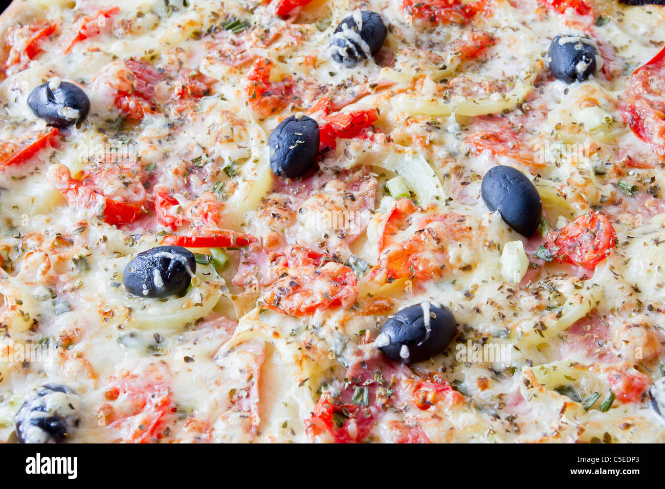 Pizza mit Mozzarella-Käse und frischen Tomaten und Pesto-Sauce. Garniert mit getrockneten Tomaten, grüne und schwarze Oliven und Basilikum Lea Stockfoto