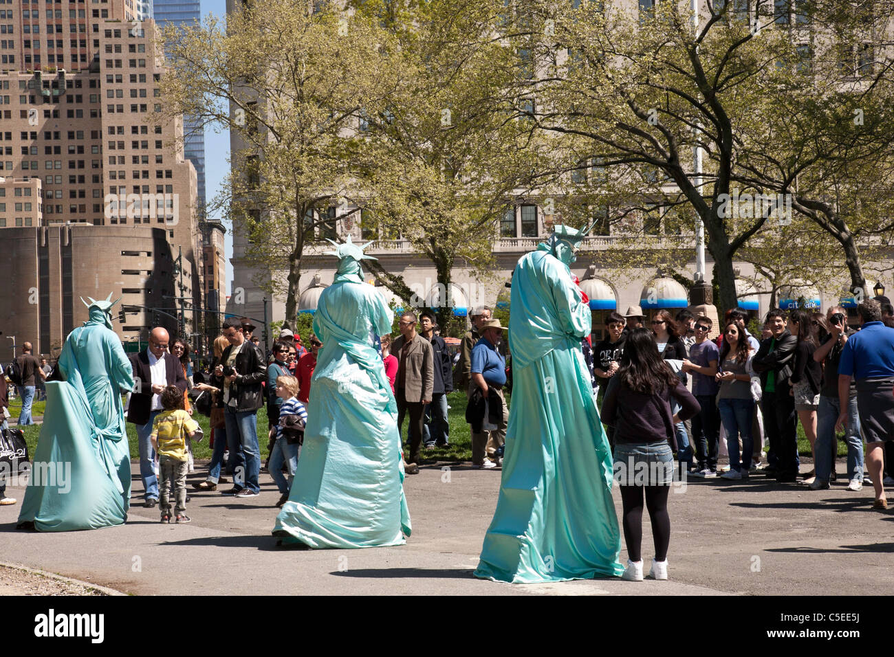 Touristen, posiert mit Statue von Liberty Street Artists, Battery Park, New York City Stockfoto