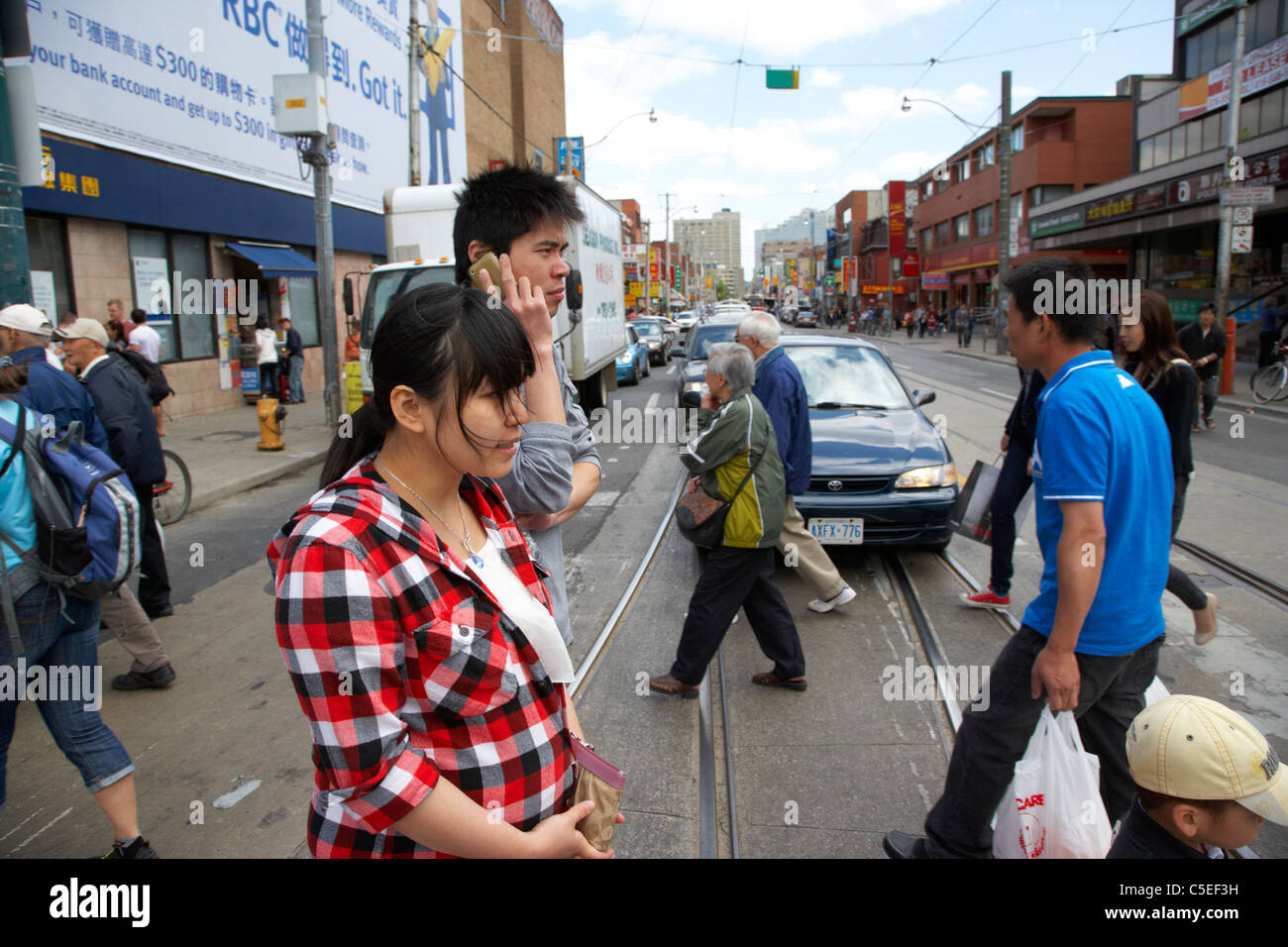 chinesische und asiatische Herkunft Menschen zu Fuß quer durch die Straße Kreuzung Innenstadt Chinatown Toronto Ontario Kanada Stockfoto