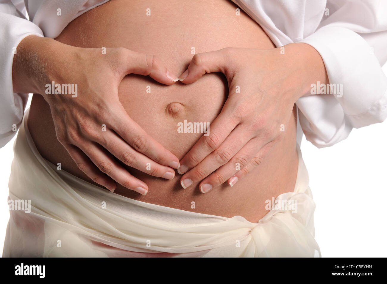 Schwangere Frau, Herzform mit Händen über ihren Bauch isoliert auf weißem Hintergrund Stockfoto