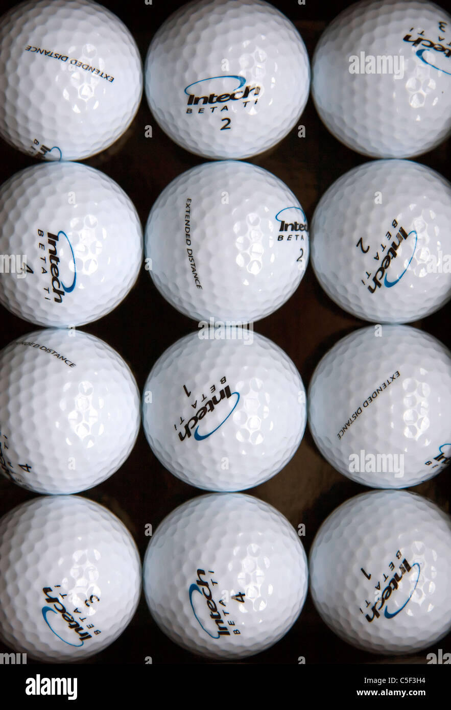 Ein Golf-Themen abstrakte Stilleben, bestehend aus einem Dutzend glänzende neue Golfbälle, symmetrisch gruppiert in Reihen. Stockfoto