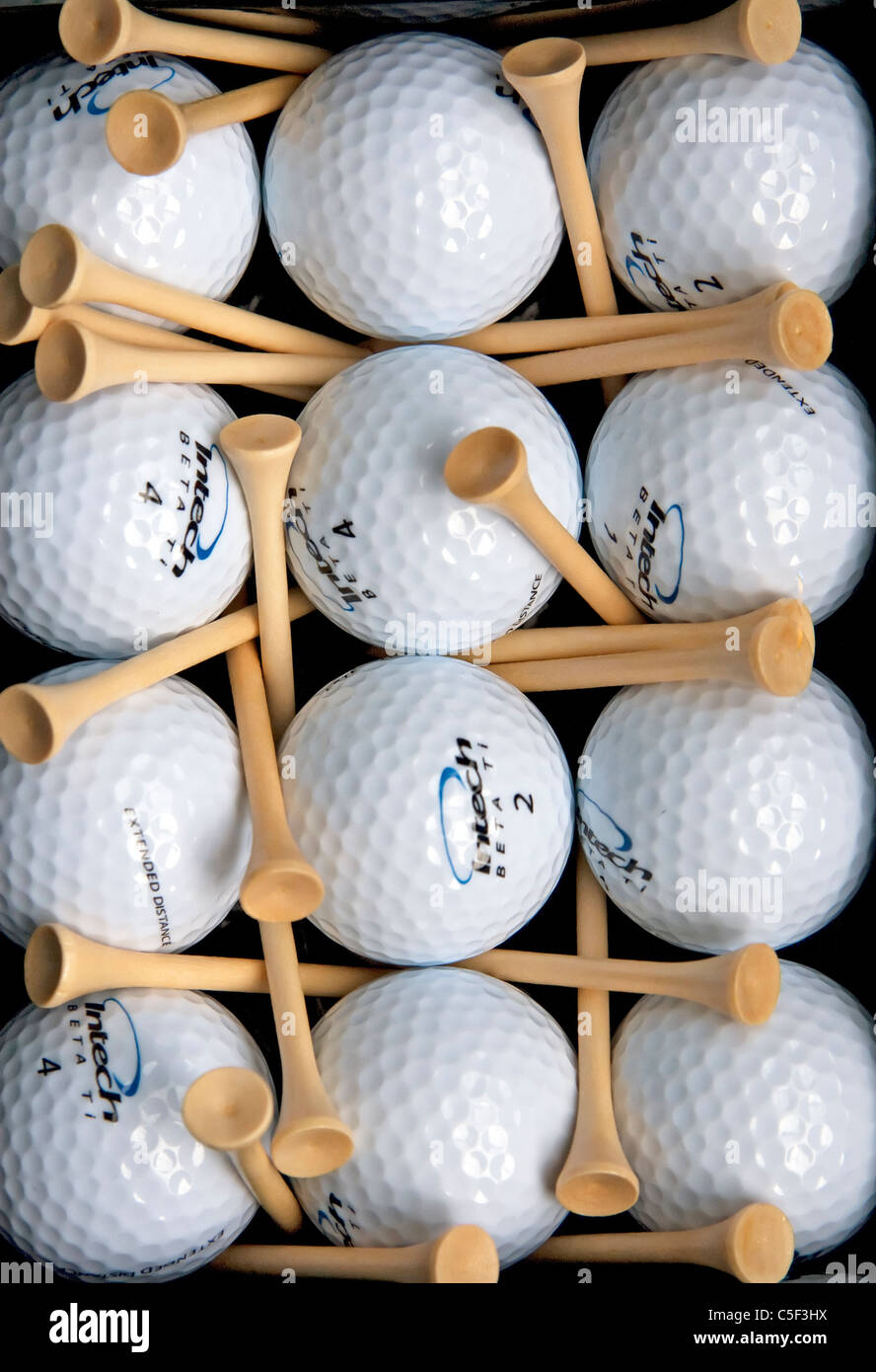 Ein Golf-Themen abstrakte Stilleben, bestehend aus 12 glänzende neue Golf, die Kugeln, symmetrisch gruppiert in Reihen mit Tees vermischt. Stockfoto