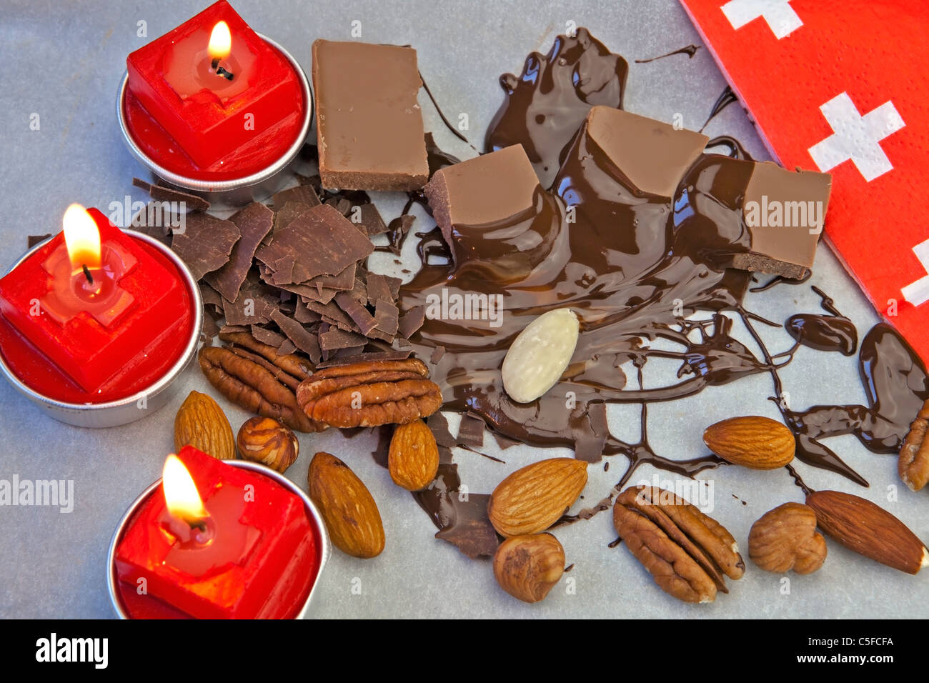 glatte Schokoladenstücke mit Schokoladensauce und Nüssen Stockfoto