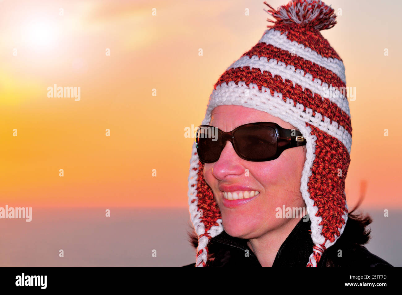 Portugal, Algarve: Mädchen mit einem selbst gemachten Algarve Hut und Sonnenuntergang am Kap Sao Vicente Stockfoto