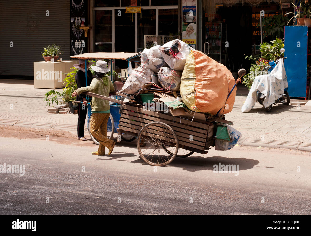 Recyclingmaterialien Plünderer ziehen einem Handwagen, beladen mit Karton und Kunststoff Abfall, Siem Reap, Kambodscha Stockfoto