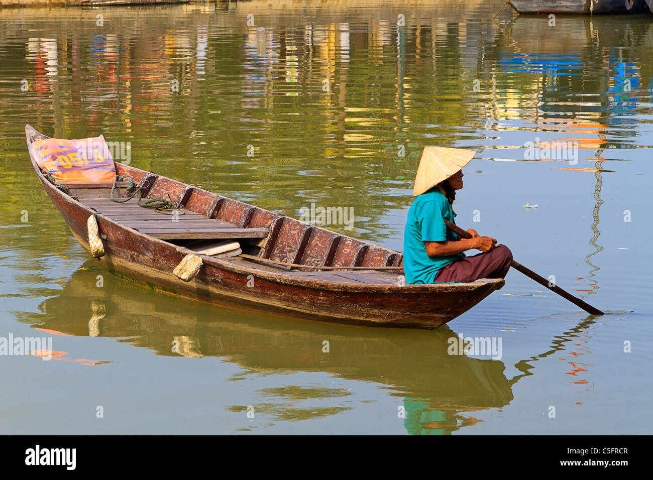 Ältere Frau Hut vietnamesische Kegel im traditionellen Boot am Fluss Thu Bon, Hoi An, Zentral-Vietnam. Stockfoto