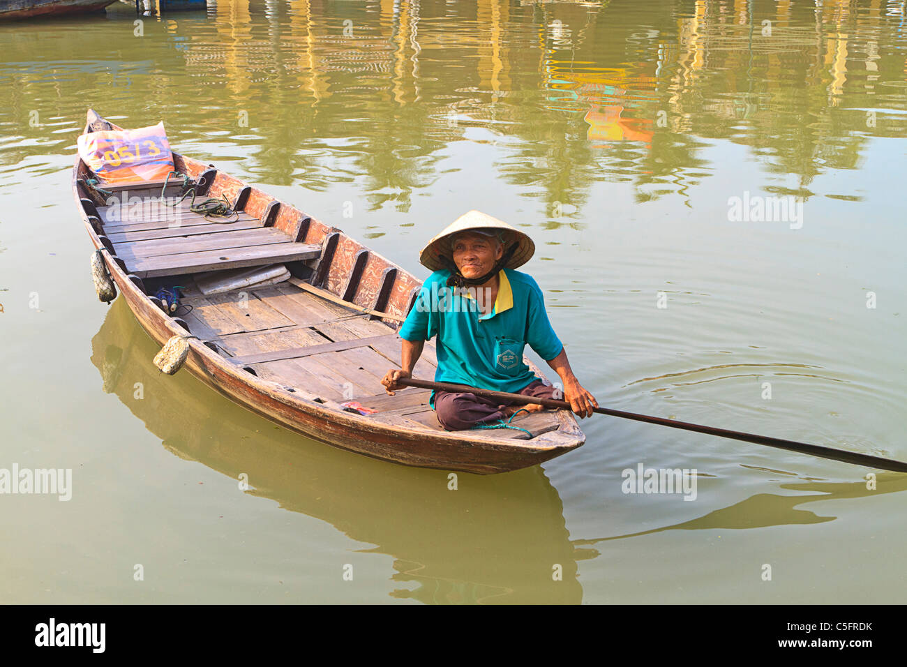 Ältere Frau Hut vietnamesische Kegel im traditionellen Boot am Fluss Thu Bon, Hoi An, Zentral-Vietnam. Stockfoto