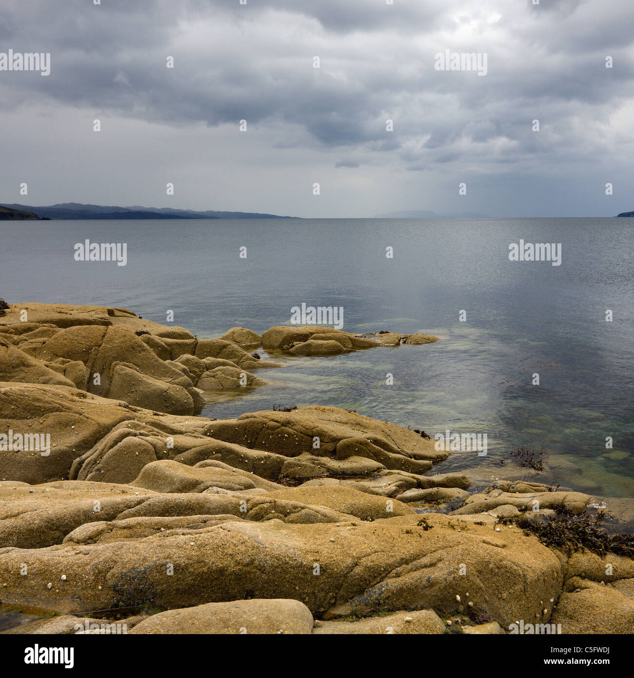 Felsenküste, ruhige See Loch mit bewölkt, bedrohlichen grauen Himmel, Camas Malag, Torrin, Isle Of Skye, Schottland, UK Stockfoto