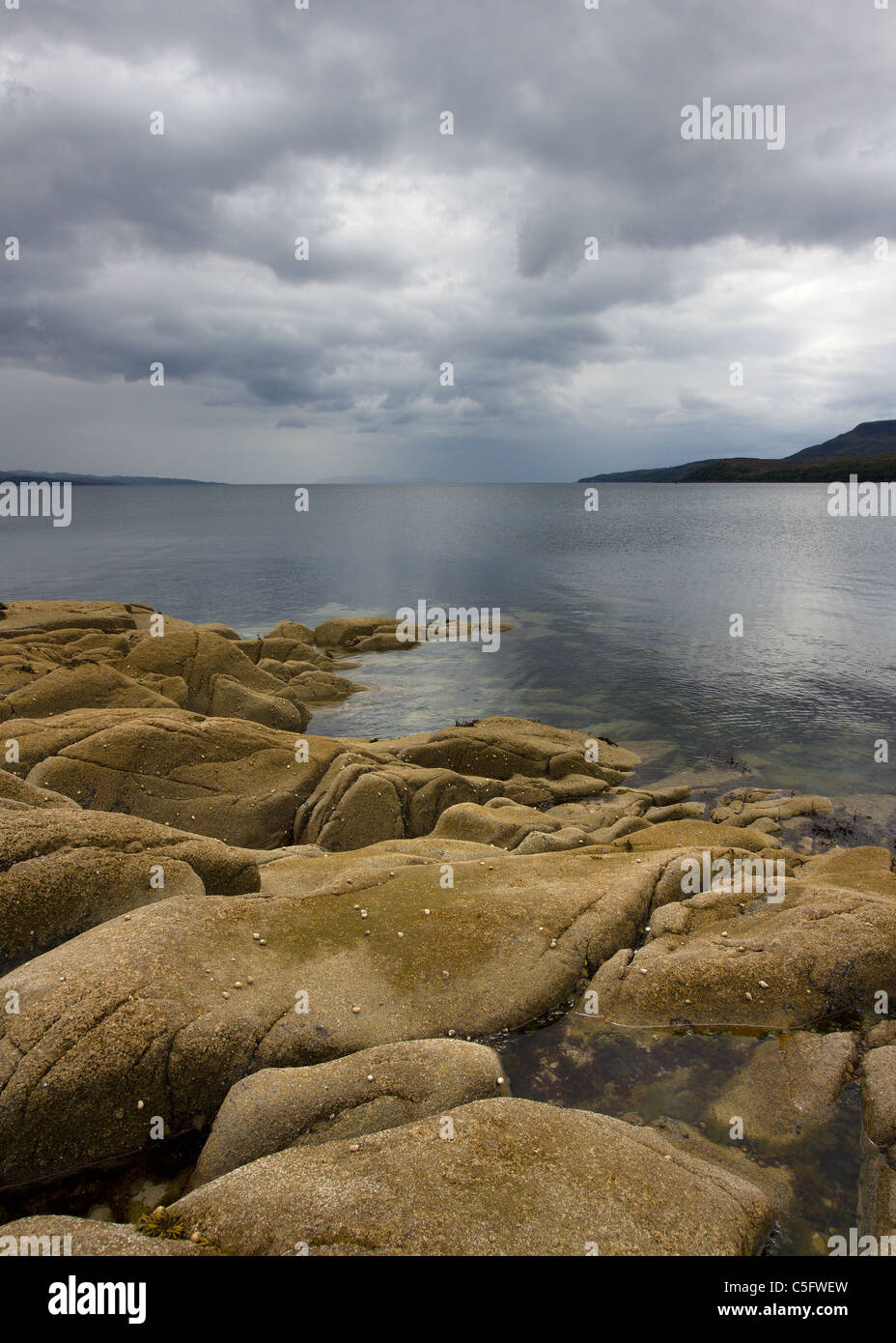 Felsenküste, ruhige See Loch mit bewölkt, bedrohlichen grauen Himmel, Camas Malag, Torrin, Isle Of Skye, Schottland, UK Stockfoto