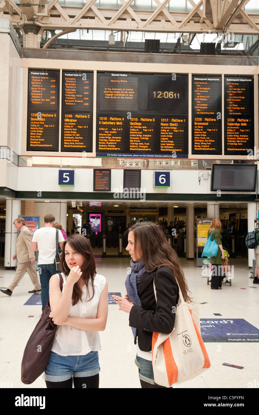 Zwei Mädchen im Teenageralter warten auf einen Zug, Bahnhof Charing Cross, London UK Stockfoto