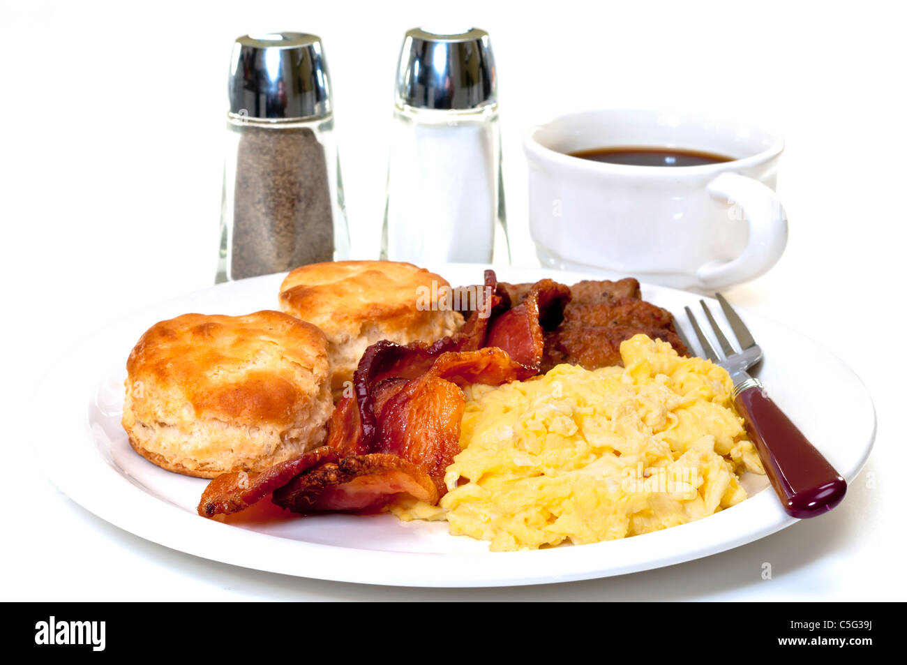 Großen Land-Frühstück mit Rührei, Speck, Wurst, Kekse Buttermilch und Kaffee.  Salz- und Pfefferstreuer. Stockfoto