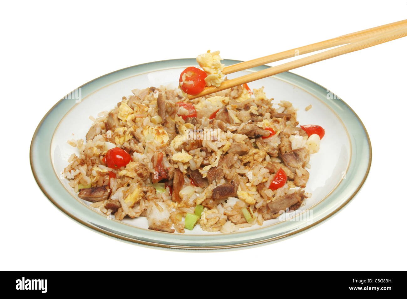 Teller mit gebratenen Reis mit Essen in Stäbchen oben gehalten Stockfoto