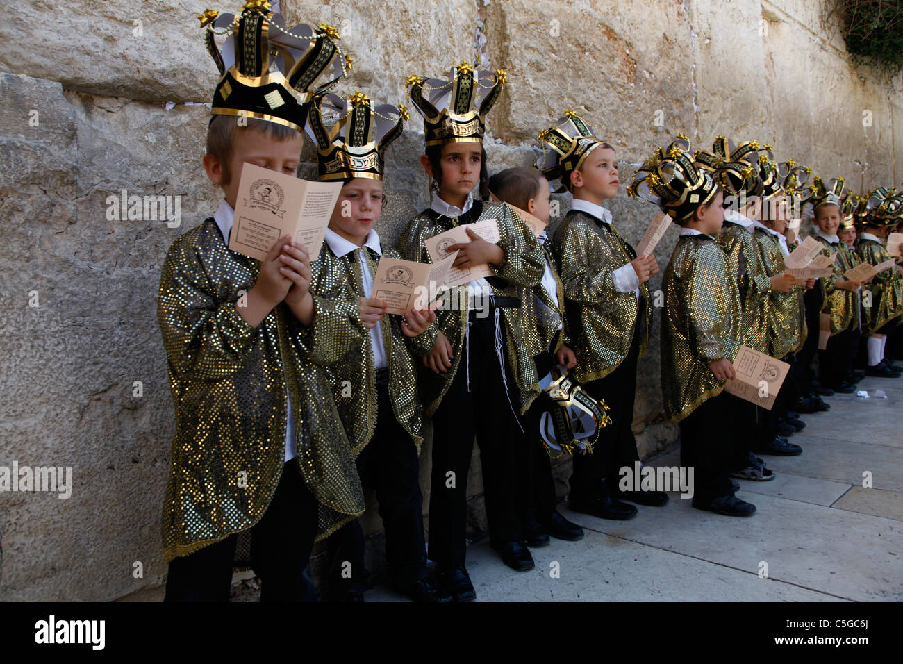 Ultra-orthodoxen Kinder tragen Thora Kronen während der Feier des jüdischen Feiertags von Shavuot, die Übergabe der Tora am Mt. Sinai, sieben Wochen nach dem Exodus des jüdischen Volkes aus Ägypten. Western Wall Altstadt Jerusalem, Israel Stockfoto