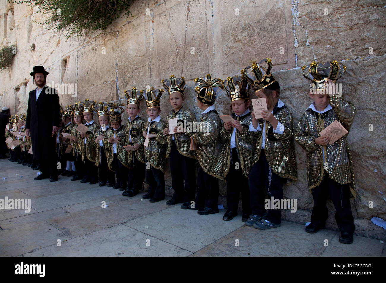 Ultra-orthodoxen Kinder tragen Thora Kronen während der Feier des jüdischen Feiertags von Shavuot, die Übergabe der Tora am Mt. Sinai, sieben Wochen nach dem Exodus des jüdischen Volkes aus Ägypten. Western Wall Altstadt Jerusalem, Israel Stockfoto