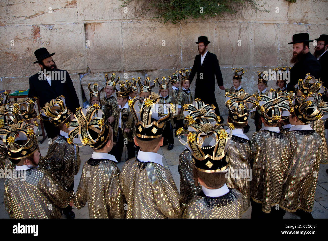 Ultra-orthodoxen Kinder tragen Thora Kronen während der Feier des jüdischen Feiertags von Shavuot, die Übergabe der Tora am Mt. Sinai, sieben Wochen nach dem Exodus des jüdischen Volkes aus Ägypten. Western Wall Altstadt Jerusalem, Israel Stockfoto