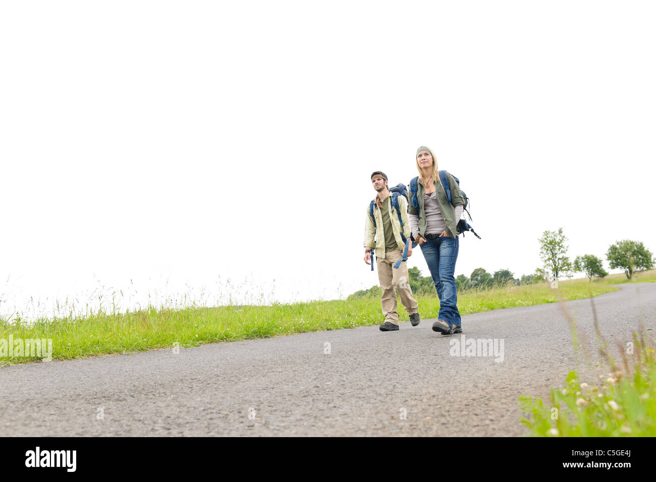 Junges Paar Wanderrucksack trampeln auf Asphalt Straße Landschaft Stockfoto