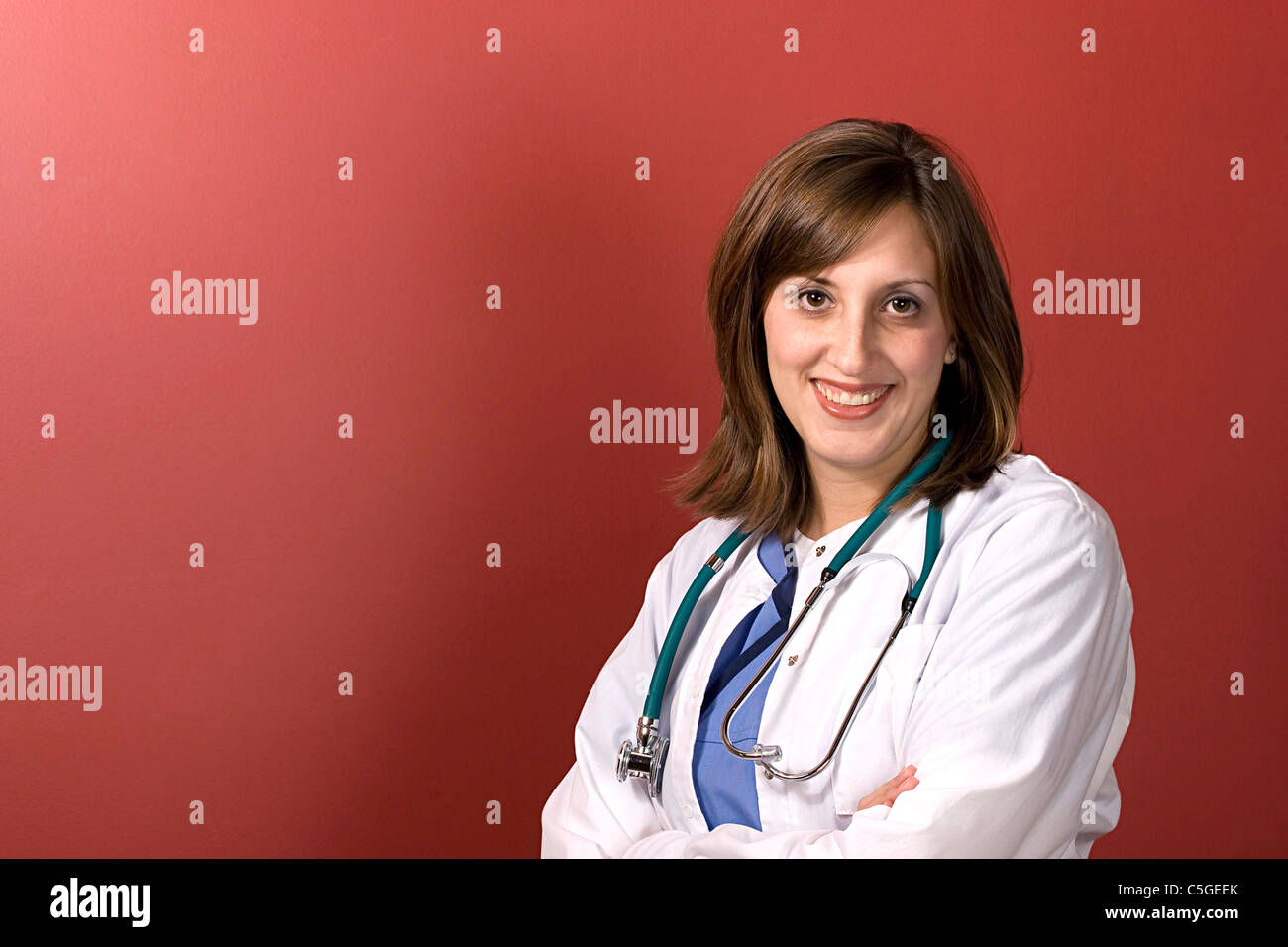 Ein junger Arzt isoliert auf einem roten Hintergrund mit Exemplar. Stockfoto