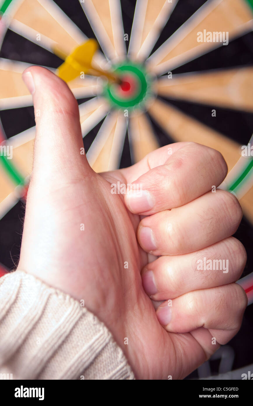 Nahaufnahme eines Dart, der einem Bullen-Auge in der Mitte von der Dartscheibe genagelt hat. Geringe Schärfentiefe. Stockfoto