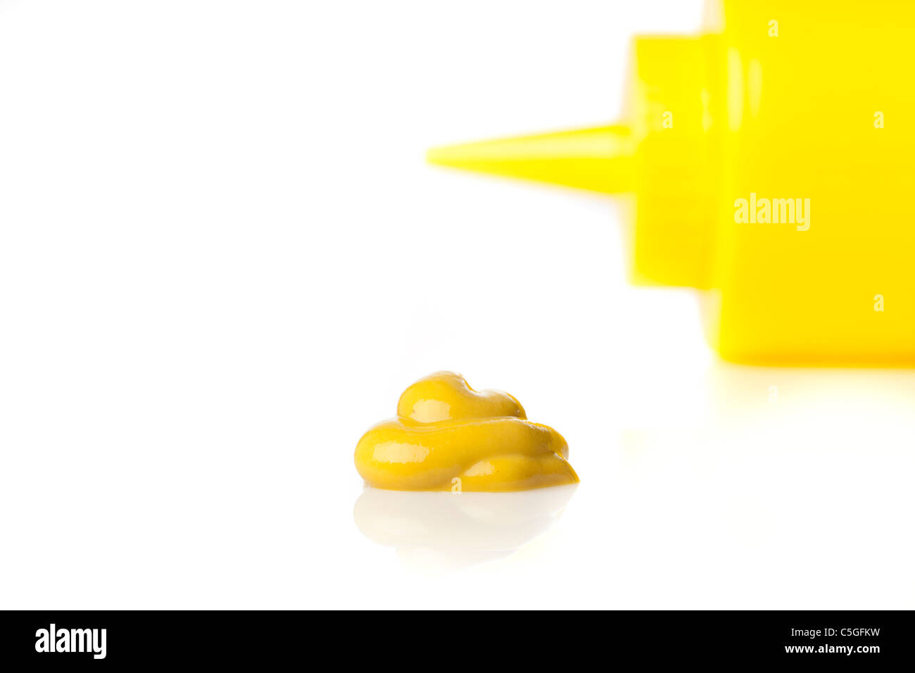 Eine gelbe Senf Flasche vor einem weißen Hintergrund Stockfoto
