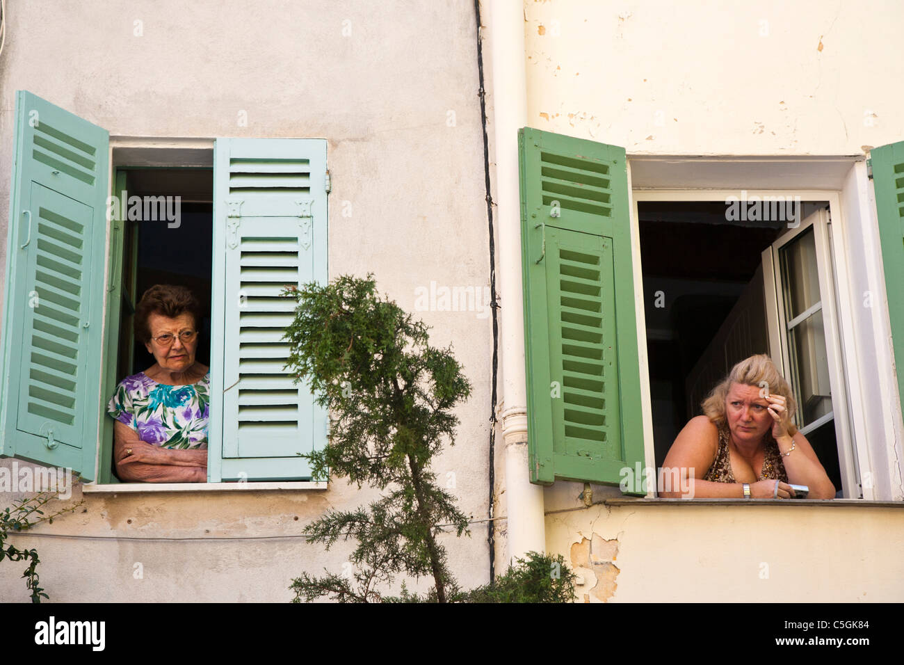 Zwei Frauen, die aus dem oberen Fenster, Roquebrune, Provence, Frankreich Stockfoto