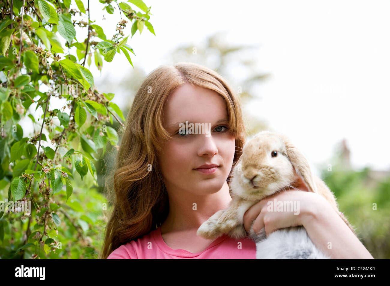 Ein junges Mädchen hält ihr Haustier Kaninchen Stockfoto