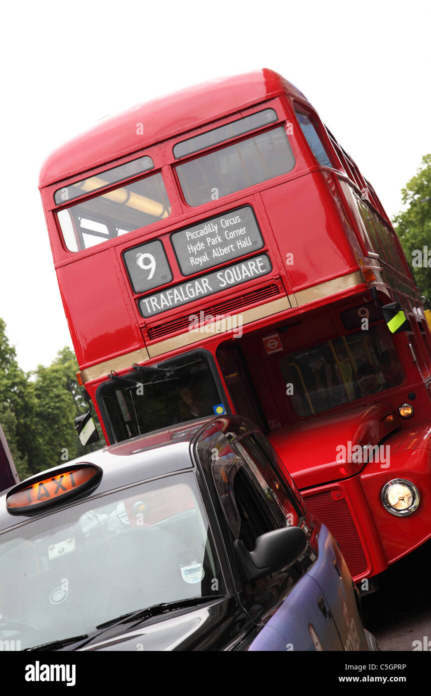 Eine rote Londoner Routemaster Bus und Taxi auf einer Londoner Straße. Stockfoto