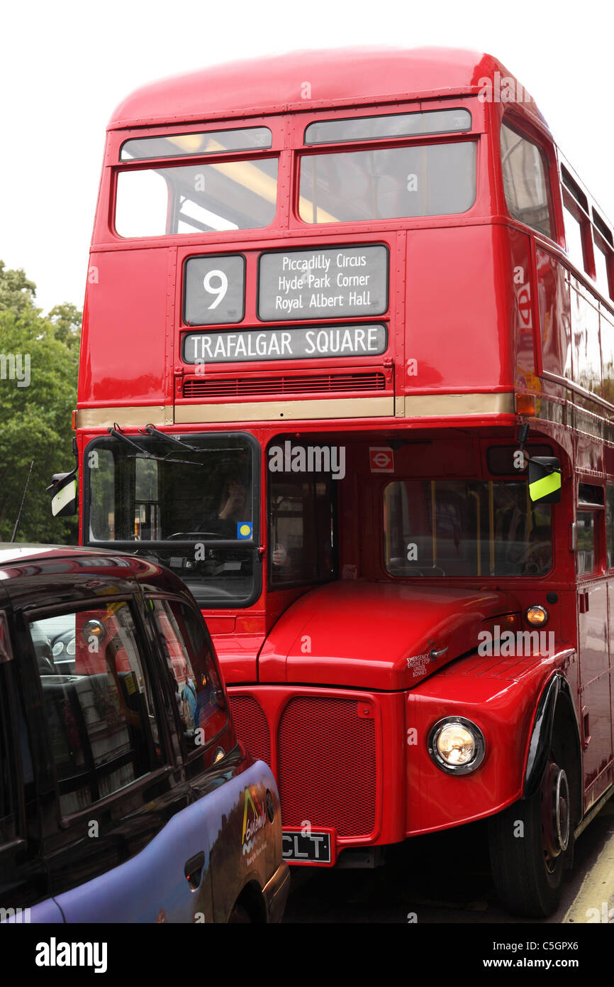 Eine rote Londoner Routemaster Bus und Taxi auf einer Londoner Straße. Stockfoto