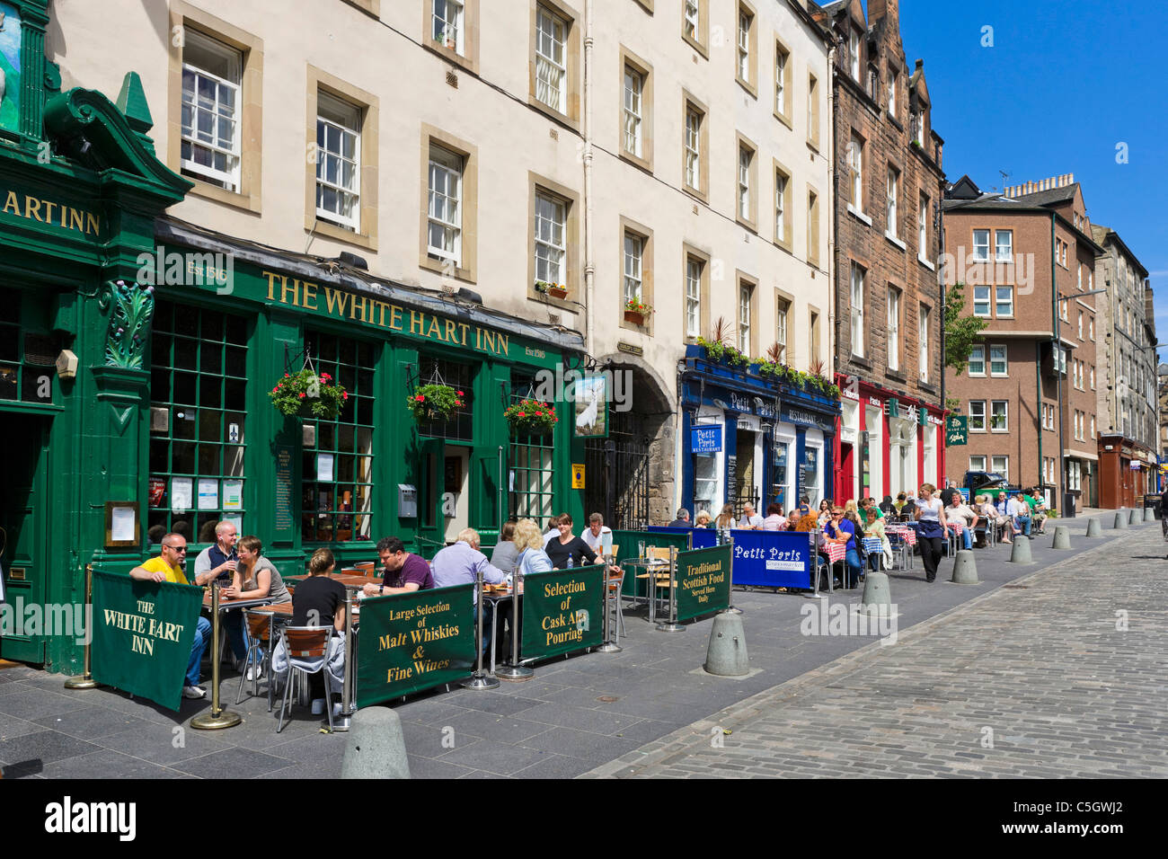 Menschen sitzen vor einem Pub (The White Hart Inn) auf Grassmarket in Old Town, Edinburgh, Schottland, Großbritannien Stockfoto