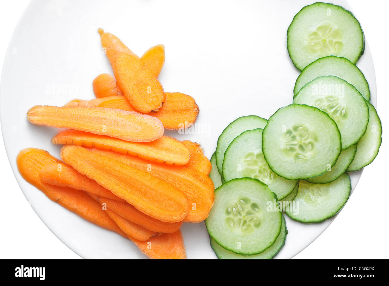 Frischen Karotten und Gurken Scheiben, angeordnet in einem weißen Teller. Stockfoto
