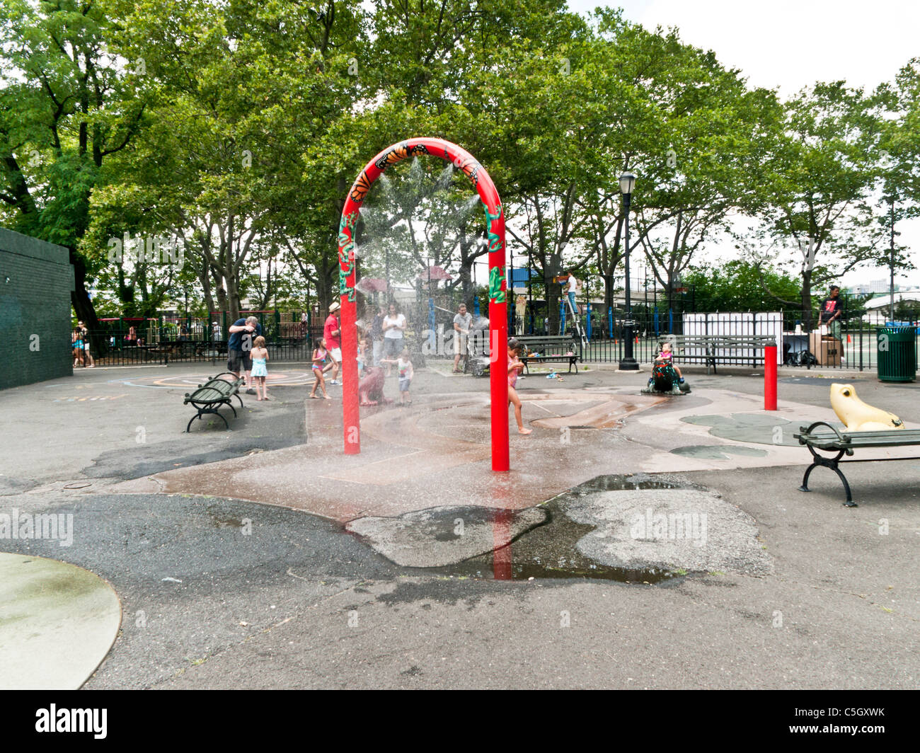 Kinder spielen im Spray Düsen Wasserspiel von DeWitt Clinton Park in Hells Kitchen Nachbarschaft New York City Stockfoto