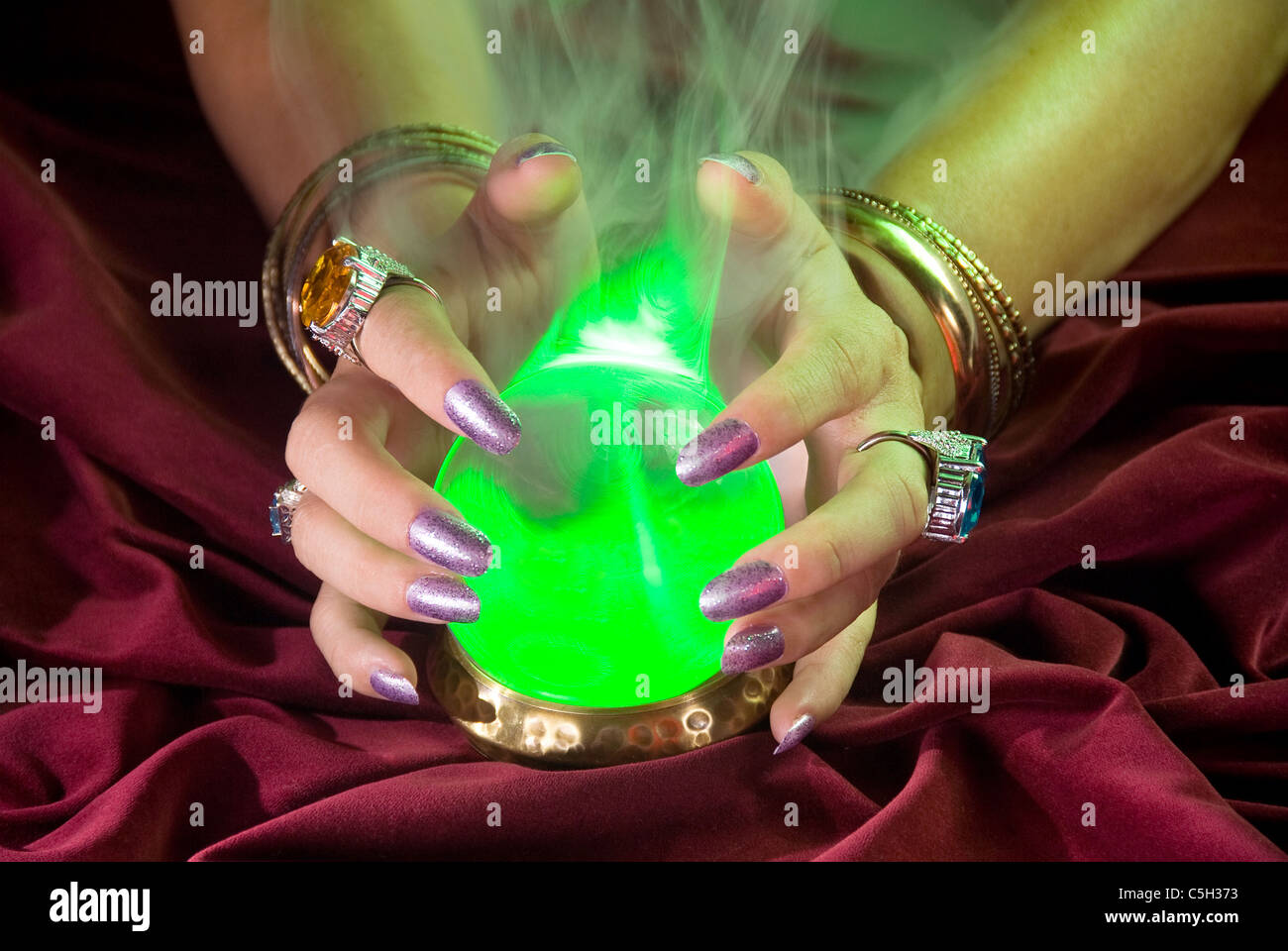 Eine Kristallkugel lebt als grünes Licht und Nebelform um das Glas. Stockfoto